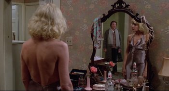 Movie still from “Chilly Scenes of Winter” (1979), directed by Joan Micklin Silver – A man standing in front of a mirror in front of two women; Medium shot, Over the shoulder angle