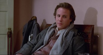 Movie still from “Chilly Scenes of Winter” (1979), directed by Joan Micklin Silver – A man sitting on a couch wearing a coat and tie; Close Up shot, Over the shoulder angle