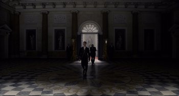 Movie still from “Darkest Hour” (2017), directed by Joe Wright – A man in a suit walks through a hall way; Extreme Wide shot, High angle
