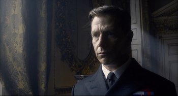 Movie still from “Darkest Hour” (2017), directed by Joe Wright – A person wearing a suit and tie; Close Up shot, Low angle