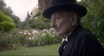 Movie still from “Darkest Hour” (2017), directed by Joe Wright – An older man in a suit and hat looking off into the distance; Close Up shot, Over the shoulder angle