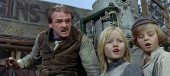 Movie still from “Chitty Chitty Bang Bang” (1968), directed by Ken Hughes – A man and a young girl standing next to each other; Close Up shot, Low angle