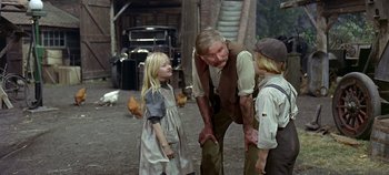 Movie still from “Chitty Chitty Bang Bang” (1968), directed by Ken Hughes – A man standing next to two children in a barn; Medium shot, Over the shoulder angle