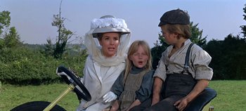 Movie still from “Chitty Chitty Bang Bang” (1968), directed by Ken Hughes – A woman and two children sitting in a carriage; Medium shot, Low angle