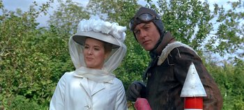 Movie still from “Chitty Chitty Bang Bang” (1968), directed by Ken Hughes – A man and a woman wearing hats posing for a picture; Medium shot, Low angle