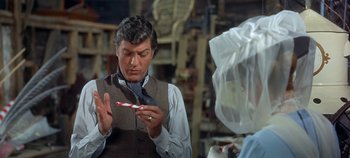 Movie still from “Chitty Chitty Bang Bang” (1968), directed by Ken Hughes – A man holding a candy cane in his hands; Close Up shot, Over the shoulder angle