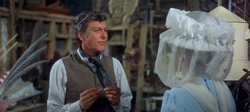 Movie still from “Chitty Chitty Bang Bang” (1968), directed by Ken Hughes – A man wearing a vest and a neck tie in front of a woman; Medium shot, Over the shoulder angle