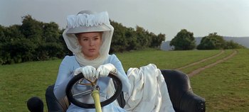 Movie still from “Chitty Chitty Bang Bang” (1968), directed by Ken Hughes – A woman sitting in the driver's seat of an old fashioned car; Medium shot, Low angle