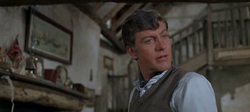 Movie still from “Chitty Chitty Bang Bang” (1968), directed by Ken Hughes – A person wearing a vest in a room; Close Up shot, Low angle