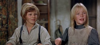 Movie still from “Chitty Chitty Bang Bang” (1968), directed by Ken Hughes – A boy and a girl are sitting in a room; Medium shot, Over the shoulder angle