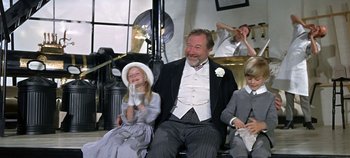 Movie still from “Chitty Chitty Bang Bang” (1968), directed by Ken Hughes – An older man sitting next to two young children; Medium shot, Low angle