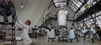 Movie still from “Chitty Chitty Bang Bang” (1968), directed by Ken Hughes – A group of people standing in a room with a statue; Wide shot, Low angle
