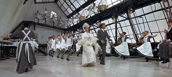 Movie still from “Chitty Chitty Bang Bang” (1968), directed by Ken Hughes – A group of men and women dressed in white; Wide shot, Low angle
