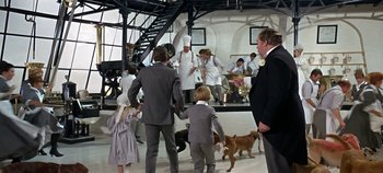 Movie still from “Chitty Chitty Bang Bang” (1968), directed by Ken Hughes – A group of people standing next to each other with a dog; Wide shot, High angle