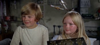 Movie still from “Chitty Chitty Bang Bang” (1968), directed by Ken Hughes – Two young children sitting next to each other in a room; Close Up shot, High angle