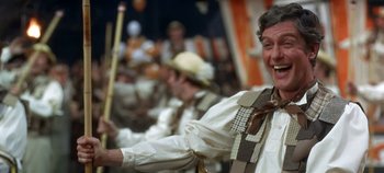 Movie still from “Chitty Chitty Bang Bang” (1968), directed by Ken Hughes – A group of people in costumes holding sticks; Medium shot, Low angle