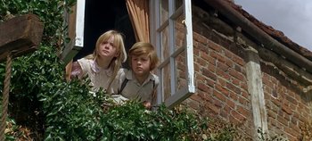 Movie still from “Chitty Chitty Bang Bang” (1968), directed by Ken Hughes – Two young children looking out of a window; Medium shot, Low angle