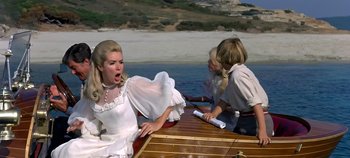 Movie still from “Chitty Chitty Bang Bang” (1968), directed by Ken Hughes – A woman and two children sitting on a boat in the water; Medium shot, Over the shoulder angle