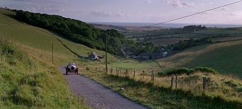 Movie still from “Chitty Chitty Bang Bang” (1968), directed by Ken Hughes – An old car driving down a road in a rural area; Extreme Wide shot, High angle