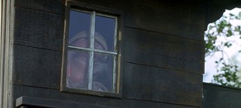 Movie still from “Chitty Chitty Bang Bang” (1968), directed by Ken Hughes – A man looking out of a window of a wooden house; Close Up shot, Low angle