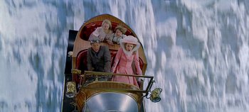 Movie still from “Chitty Chitty Bang Bang” (1968), directed by Ken Hughes – A group of people riding in the back of a boat; Wide shot, Overhead angle