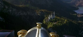 Movie still from “Chitty Chitty Bang Bang” (1968), directed by Ken Hughes – A view of a castle on a hill from the top of a building; Extreme Wide shot, Low angle