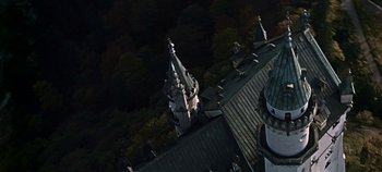 Movie still from “Chitty Chitty Bang Bang” (1968), directed by Ken Hughes – An aerial view of a building with a clock on it; Extreme Wide shot, Overhead angle