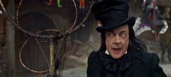 Movie still from “Chitty Chitty Bang Bang” (1968), directed by Ken Hughes – A woman wearing a black hat and a black coat; Medium shot, Low angle