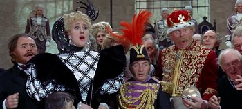 Movie still from “Chitty Chitty Bang Bang” (1968), directed by Ken Hughes – A group of people dressed up in costumes; Medium shot, Low angle