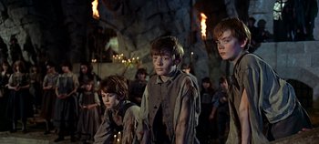 Movie still from “Chitty Chitty Bang Bang” (1968), directed by Ken Hughes – A group of young people standing next to each other in a cave; Medium shot, Low angle
