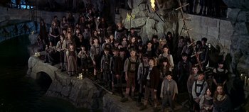 Movie still from “Chitty Chitty Bang Bang” (1968), directed by Ken Hughes – A large group of children standing next to each other in a cave; Wide shot, High angle