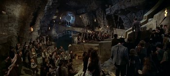 Movie still from “Chitty Chitty Bang Bang” (1968), directed by Ken Hughes – A group of people sitting in a cave; Extreme Wide shot, High angle