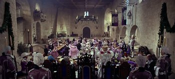 Movie still from “Chitty Chitty Bang Bang” (1968), directed by Ken Hughes – A group of people dressed in costumes in a room; Wide shot, High angle