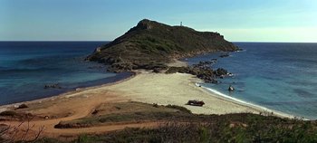 Movie still from “Chitty Chitty Bang Bang” (1968), directed by Ken Hughes – A sandy beach near the ocean with a lighthouse in the distance; Extreme Wide shot, High angle