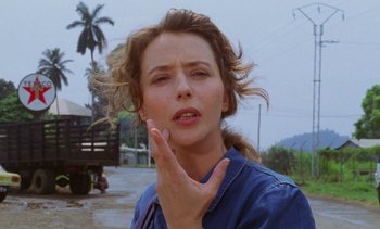 Movie still from “Chocolat” (1988), directed by Claire Denis – A person holding their hand up to her face; Close Up shot, Low angle