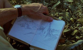 Movie still from “Chocolat” (1988), directed by Claire Denis – A man holding a book with a drawing of a mountain; Extreme Close Up shot, Low angle