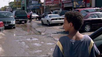 Movie still from “Chop Shop” (2007), directed by Ramin Bahrani – A young boy is standing in the middle of the street; Medium shot, Over the shoulder angle