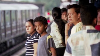 Movie still from “Chop Shop” (2007), directed by Ramin Bahrani – A group of people standing next to each other on a train platform; Medium shot, Over the shoulder angle