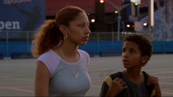 Movie still from “Chop Shop” (2007), directed by Ramin Bahrani – A woman and a boy standing next to each other on the street; Close Up shot, Low angle