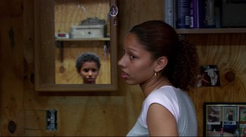 Movie still from “Chop Shop” (2007), directed by Ramin Bahrani – A young woman looking at a mirror in a room; Medium shot, Over the shoulder angle