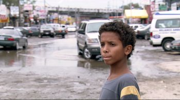 Movie still from “Chop Shop” (2007), directed by Ramin Bahrani – A young boy standing in the middle of the street; Close Up shot, Over the shoulder angle