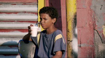 Movie still from “Chop Shop” (2007), directed by Ramin Bahrani – A young boy holding a cup in his hand; Close Up shot, Over the shoulder angle