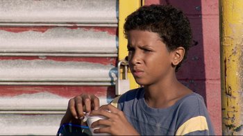 Movie still from “Chop Shop” (2007), directed by Ramin Bahrani – A young boy is holding a cup of coffee; Close Up shot, High angle