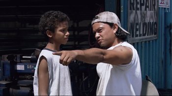 Movie still from “Chop Shop” (2007), directed by Ramin Bahrani – A man and a boy pointing at each other in front of a building; Medium shot, Low angle