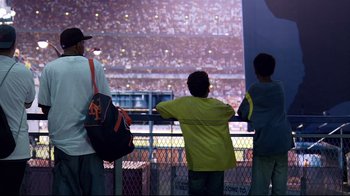 Movie still from “Chop Shop” (2007), directed by Ramin Bahrani – A group of people watching a baseball game from the stands; Wide shot, Low angle