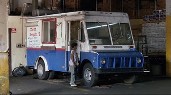 Movie still from “Chop Shop” (2007), directed by Ramin Bahrani – A man standing in front of an ice cream truck; Wide shot, Low angle