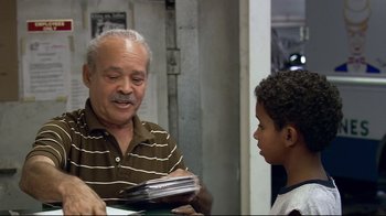 Movie still from “Chop Shop” (2007), directed by Ramin Bahrani – An older man and a young boy are looking at papers; Medium shot, Over the shoulder angle