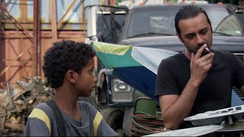 Movie still from “Chop Shop” (2007), directed by Ramin Bahrani – A man sitting next to a young boy in front of a truck; Medium shot, Over the shoulder angle