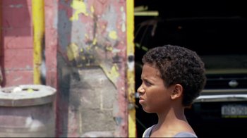 Movie still from “Chop Shop” (2007), directed by Ramin Bahrani – A young boy standing in front of an old building; Close Up shot, Over the shoulder angle