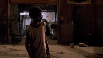 Movie still from “Chop Shop” (2007), directed by Ramin Bahrani – A young boy is standing in a room; Medium shot, Over the shoulder angle